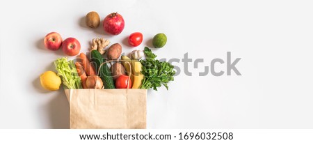 Delivery healthy food background. Vegan vegetarian food in paper bag vegetables and fruits on white, copy space, banner.Grocery shopping food supermarket and clean vegan eating concept. 商業照片 © 