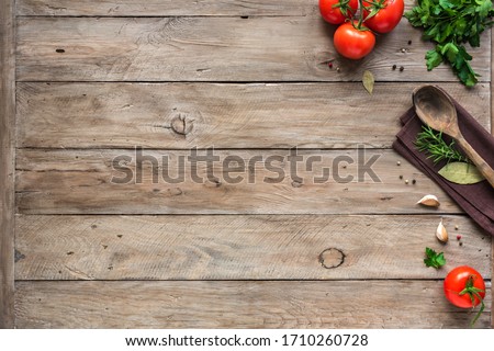 Cooking background, home cooking concept. Ripe tomatoes, spoon, herbs and spices on wooden background, top view, copy space.