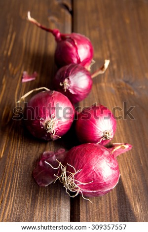 Red onion on wooden background close up