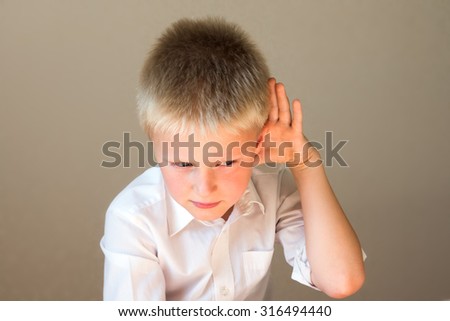 Child listening overhearing something with hand to ear concept