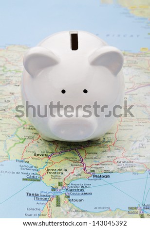 Piggy bank on top of a map symbol of world economy or holiday savings