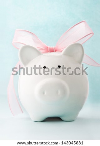 Cute piggy bank with pink bow and ribbon. Front view