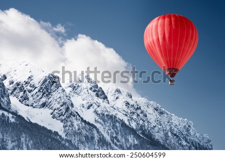 Colorful hot-air balloon flying over snowcapped mountain