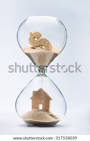 Hourglass house mortgage concept.House made out of falling sand from dollar sign flowing through hourglass