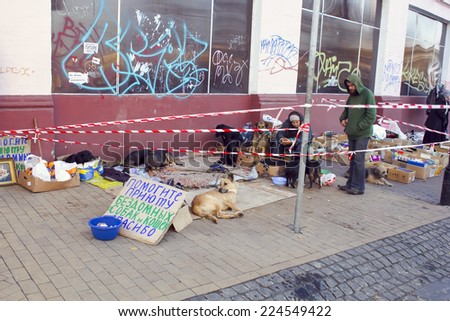 Kiev, UKRAINE - 27 October 2013: people with  stray dogs on the street holding a sign about the help