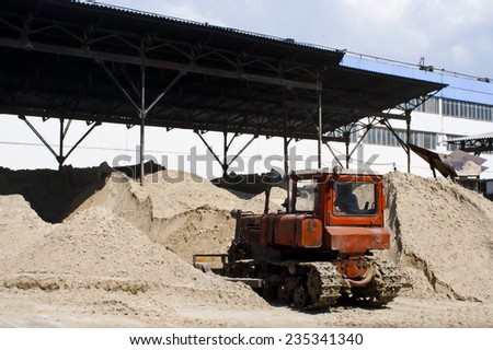KIEV, UKRAINE - May 17 2013: The territory of the of the concrete plant. Bulldozer is gaining sand