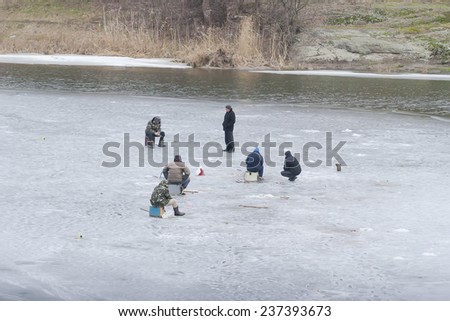 Kiev region, UKRAINE - February 17 2013: A winter fishing on river. People is fishing.