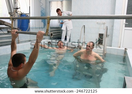 Khmelnik, UKRAINE - 20 May 2011: Group of people, mature man, at water gymnastics or aquarobics