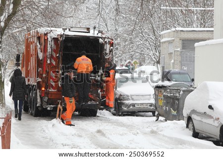 Kiev, UKRAINE - 05 February 2015: Workers of urban municipal recycling garbage collector truck loading waste and trash bin