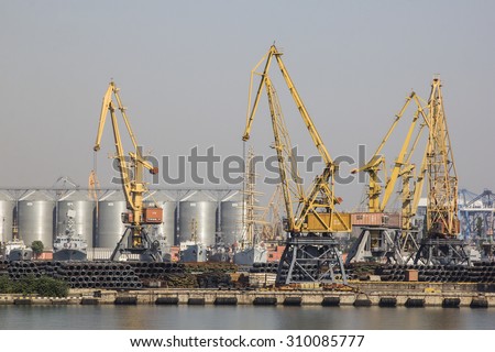 Odessa, Ukraine - July 26, 2015: Cargo cranes on rails and cargo warehouses in the seaport. Port of Odessa is the largest Ukrainian seaport with annual traffic capacity of 40 million tonnes