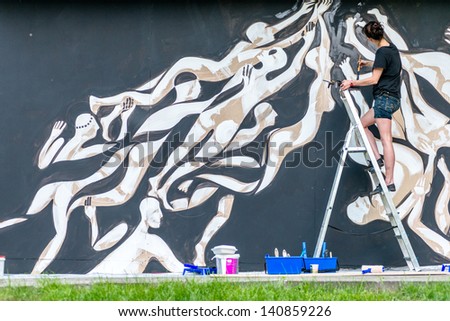 MOSCOW, RUSSIA - 1 JUNE: Lucy Mclauchlan paints the wall on Moscow Ahmad Tea Music Festival. Moscow, 1 June, 2013
