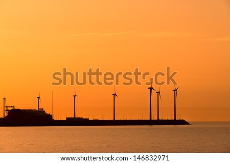 Electrical windmills silhouettes in the sunset