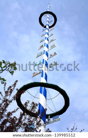 Blue and white Bavarian maypole on blue sky, horizontal