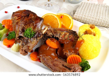 Baked wild rabbit meat with potato dumplings and vegetables, close up