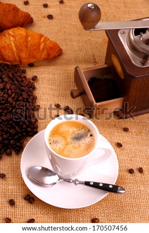 Coffee in white cup and coffee mill, vertical