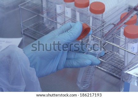 Lab technician takes sample from test tube for test, soft focus