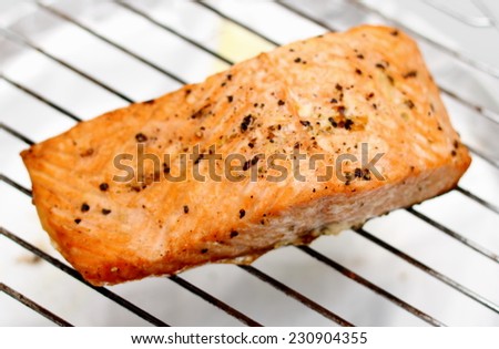 Grilled salmon fillet on grill, soft focus, top view