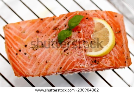Marinated salmon fillet with lemon on grill, soft focus, top view