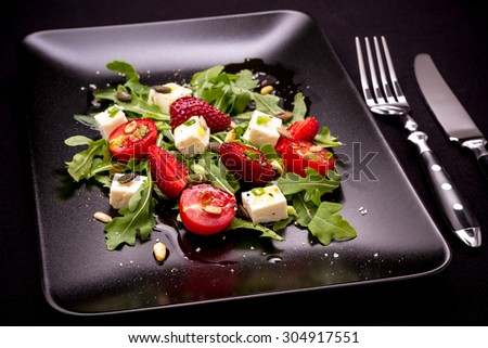 Strawberry, tomato salad with feta cheese, olive oil and cutlery
