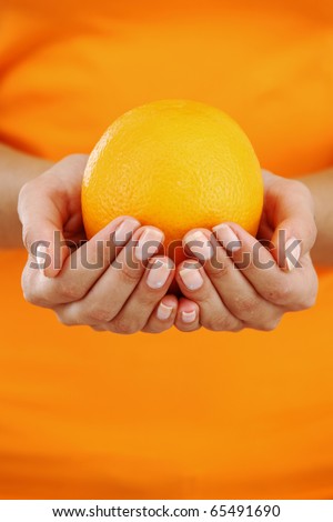 orange in woman hands