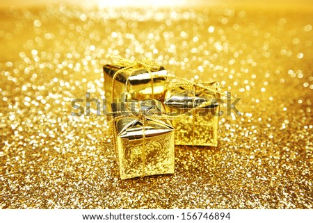 Golden boxes with christmas gifts on shiny glitter background