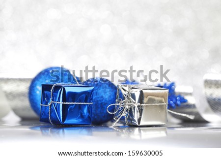 Christmas decoration ball and ribbon on silver glitter background