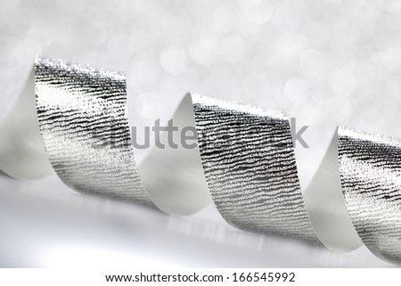 Card with silver gift bow on shiny background
