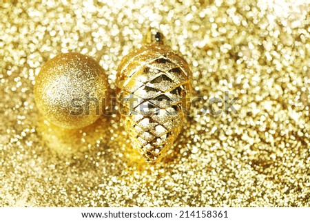 Golden christmas balls on shining glitter background close-up