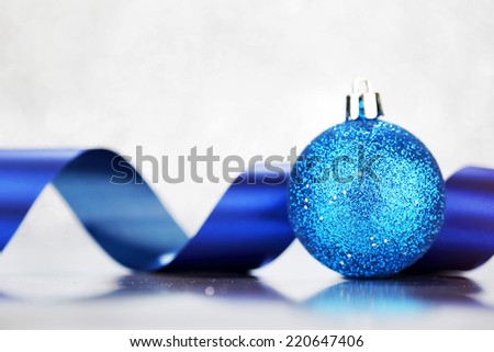 Beautiful Glitter christmas ball and ribbon close-up on shining background