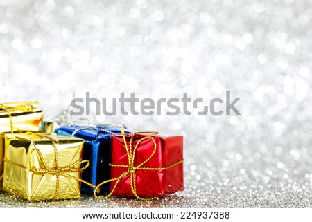 Holiday gifts in colorful boxes on silver bokeh background