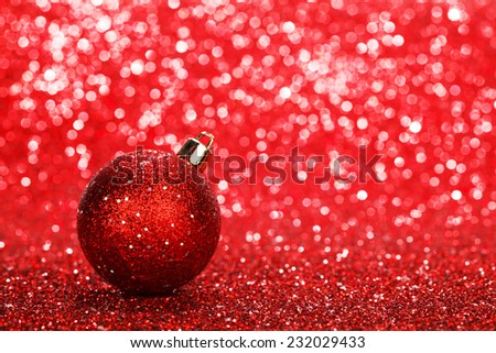 Red christmas ball over shiny glitter background