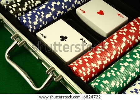 A poker set, two decks of cards with aces on top, several poker chips in a metal case.