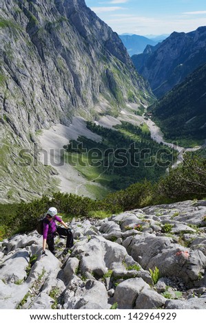 Woman climbing on a rocky path in the mountains, Germany