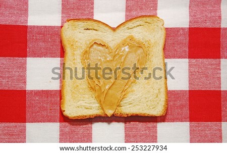 Peanut butter spread in a heart shape on a piece of toast