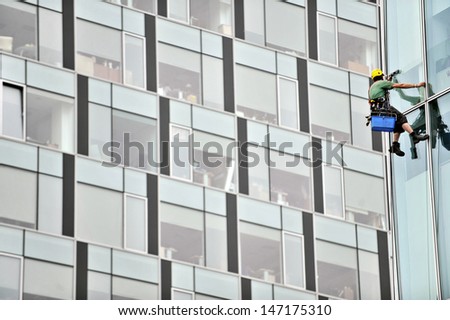 Image, Stock Photo Unrecognizable alpinist cleaning windows of building