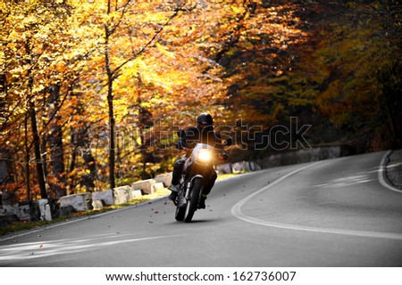 Cheia, Romania - 20 October 2013: A motorcyclist on Cheia road in mid autumn. Cheia is one of the most beautiful motorable roads in Romania.