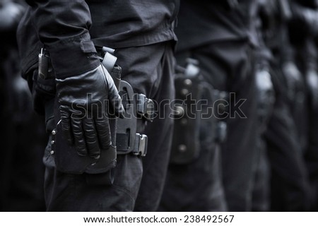 Soldier hand in black glove holding a pistol during a military parade