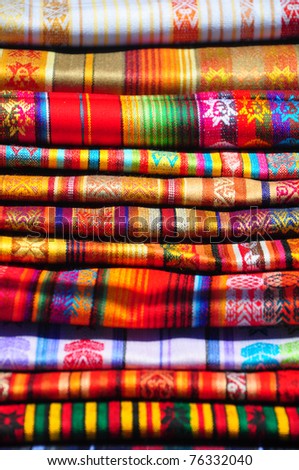 Brightly coloured woven textiles in craft market, Ecuador
