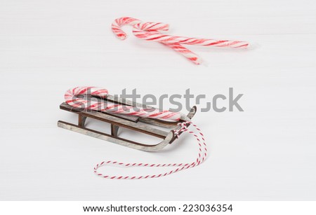 Christmas Candy Cane On Wooden Sledge. White Painted Wood Background.
