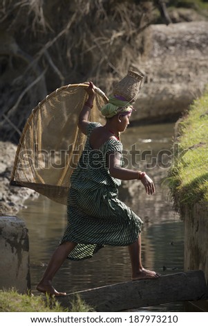 Bardia Nepal - November 11, 2013: Nepali Taru woman wear traditionnal hat and nest used for river fishing.