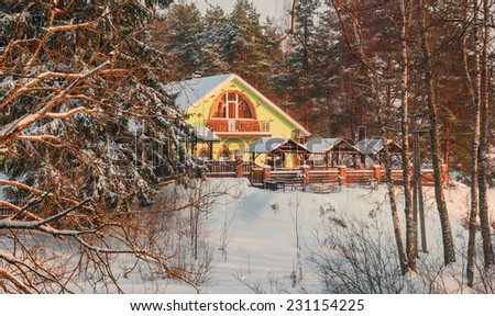 Little house in snowy forest at sunset