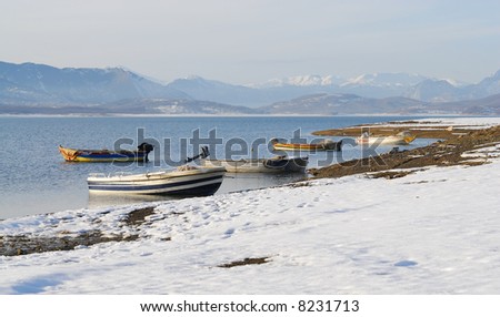 Boats in the lake and snow on the lakesides