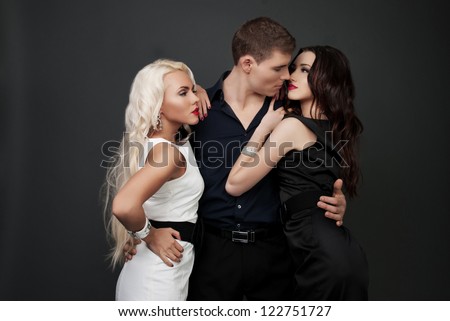Love triangle of two women, one man passion of love and hate. Man and two women blonde and brunette, love, sexy - the modern concept of love story for three people. Hatred between the two women.
