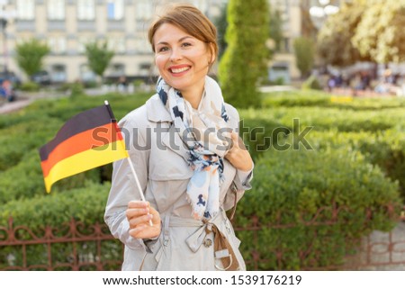 Happy middle aged woman with the German flag on a background of the park and the city. ストックフォト © 