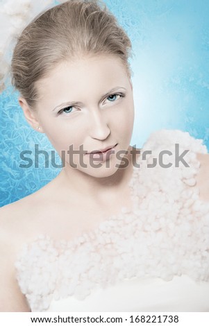 The Snow Queen. Witch and witchcraft. Winter frosty beautiful woman. Rime and frost background in a portrait of a girl. Winter Christmas story. Fabulous Christmas image for the legend of the winter.