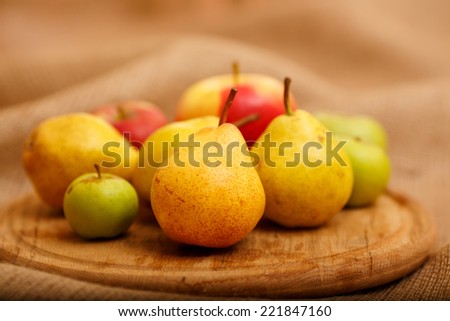 Still, the composition of different kinds of apples and pears. Autumn harvest fruit piled on a table. Apples of various colors, red, green, yellow. Ripe fruit on the table next to each other. autumn