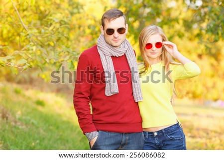 Romantic young couple in casual clothes together. Man and woman in different glasses on his face. Portrait of stylish young couple man and woman both wearing sunglasses. Walk in nature on a sunny day.