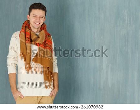 Cheerful young European man looking at camera. Portrait of a smile young man standing with against gray background. Handsome caucasian man smiling. Male model. Copy space. Friendly face.