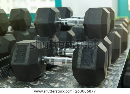 Gym. Gymnasium with sports equipment. Dumbbells, barbells, dumbbells - equipment to work on muscle mass. Morning exercises for vitality afternoon. Rows of dumbbells in the gym.
