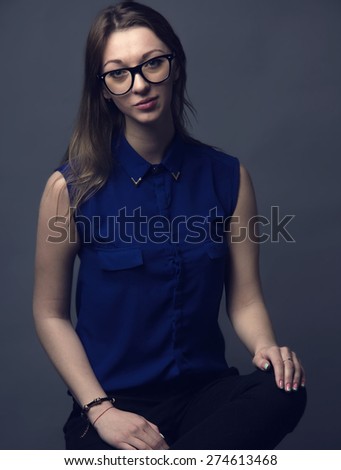 Portrait elegant fashion woman wearing glasses on dark background. Portrait of a business of a modern woman. Dark portrait of a woman wearing glasses. Young beautiful woman on a dark background.